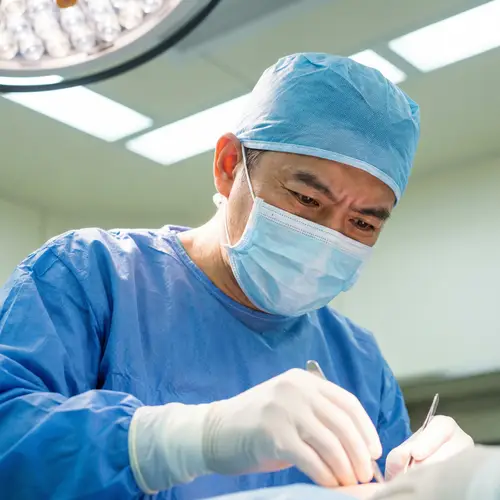 Sterile Surgery Attire | Concentrated East Asian Surgeon Photo