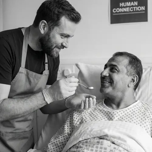 Compassionate Male Care Worker Assisting Bed-Bound Individual in Medication Administration