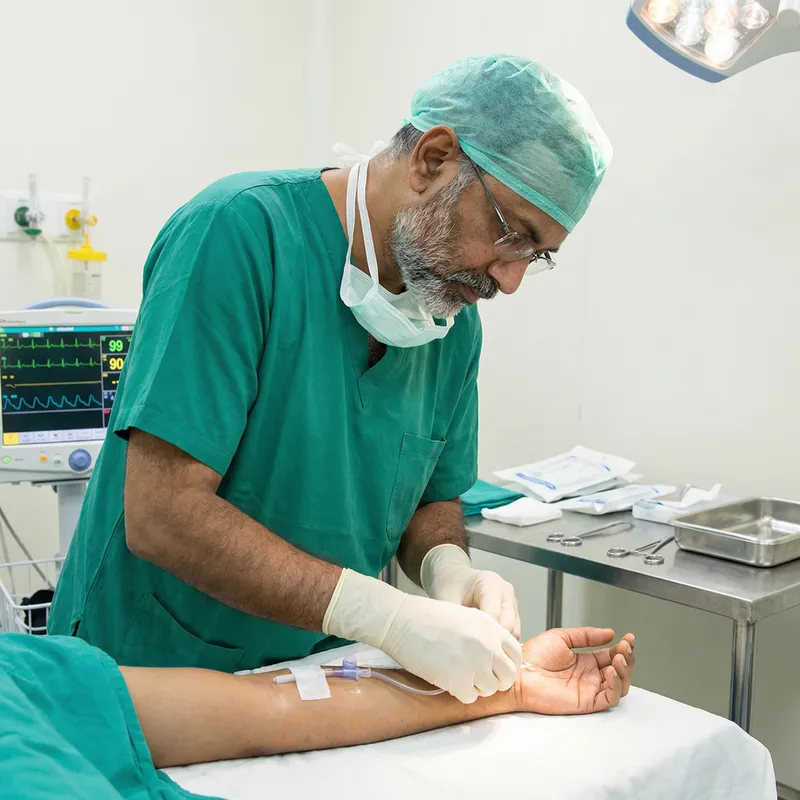 Caring Nurse with Arterial Cannula in Hospital