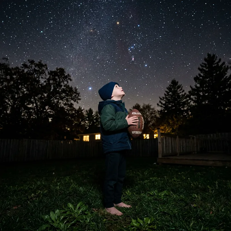 Child Gazing at Stars While Holding Football