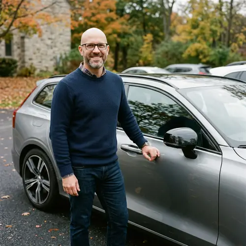 Handsome Bald Man with Glasses Poses by Car | Automotive Photos