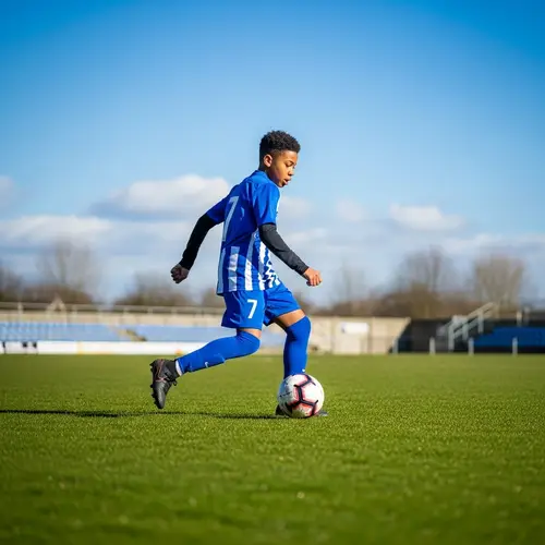 Professional Football Player in Junior Team Uniform on Grassy Field