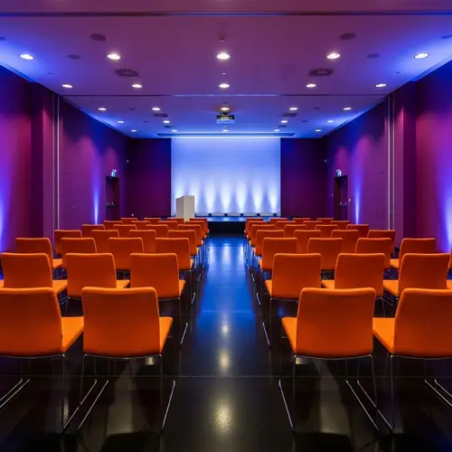 Elegant Conference Hall with Purple Walls & Orange Chairs