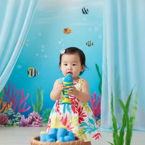 Adorable Asian Baby Girl Playing Joyously with Colorful Fish