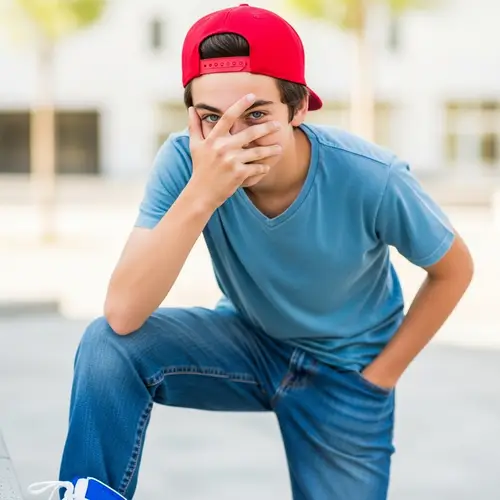 Mischievous Teenage Boy with Red Cap and Dark Hair