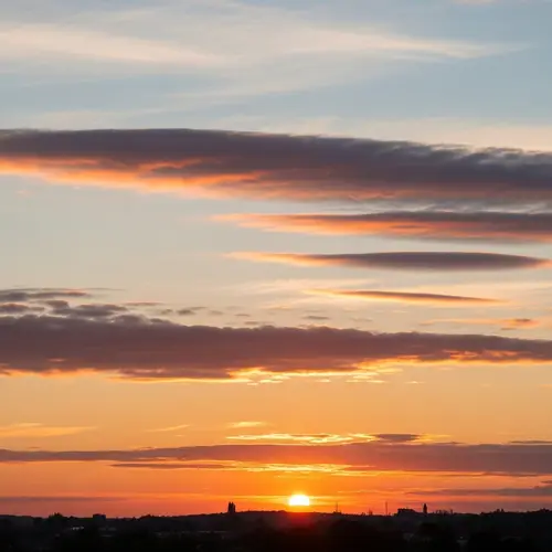 Soft Realistic Sunset with Horizontal White-Blue Clouds