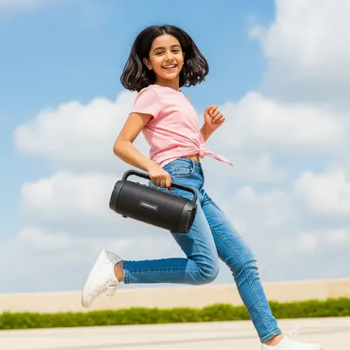 Joyful Middle-Eastern Girl Jumping with Speaker | Outdoor Happiness