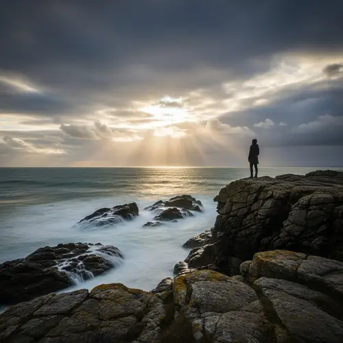 Solitary Figure atop Rugged Cliff by Tempestuous Sea