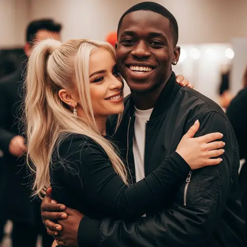 Petite Female Pop Star Embracing Smiling Black Person
