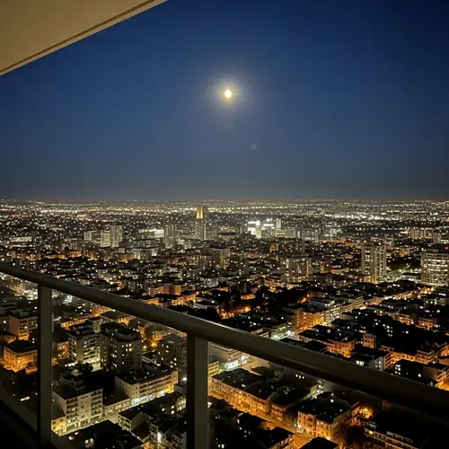 Night Cityscape with Full Moon: Serene Views from High Balcony