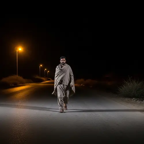 South Asian Male Walking on Desolate Road at Night