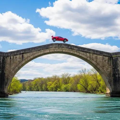 Red High-Performance Car Leaping Off Stone Bridge Over River