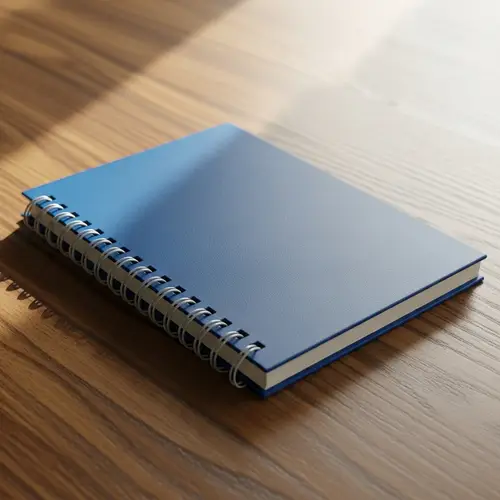 Blue Spiral Notebook on Wooden Desk