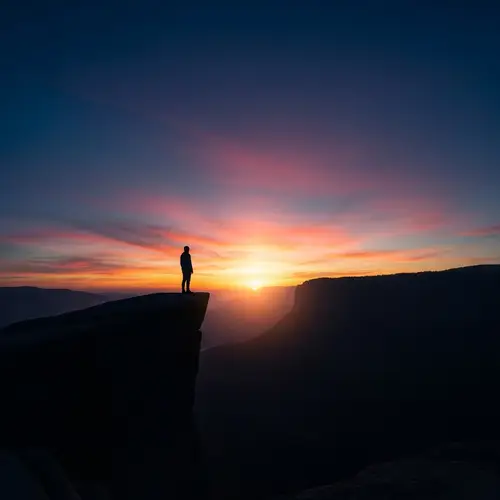 Solitary Figure on Cliff at Sunrise - Awe-Inspiring Landscape View