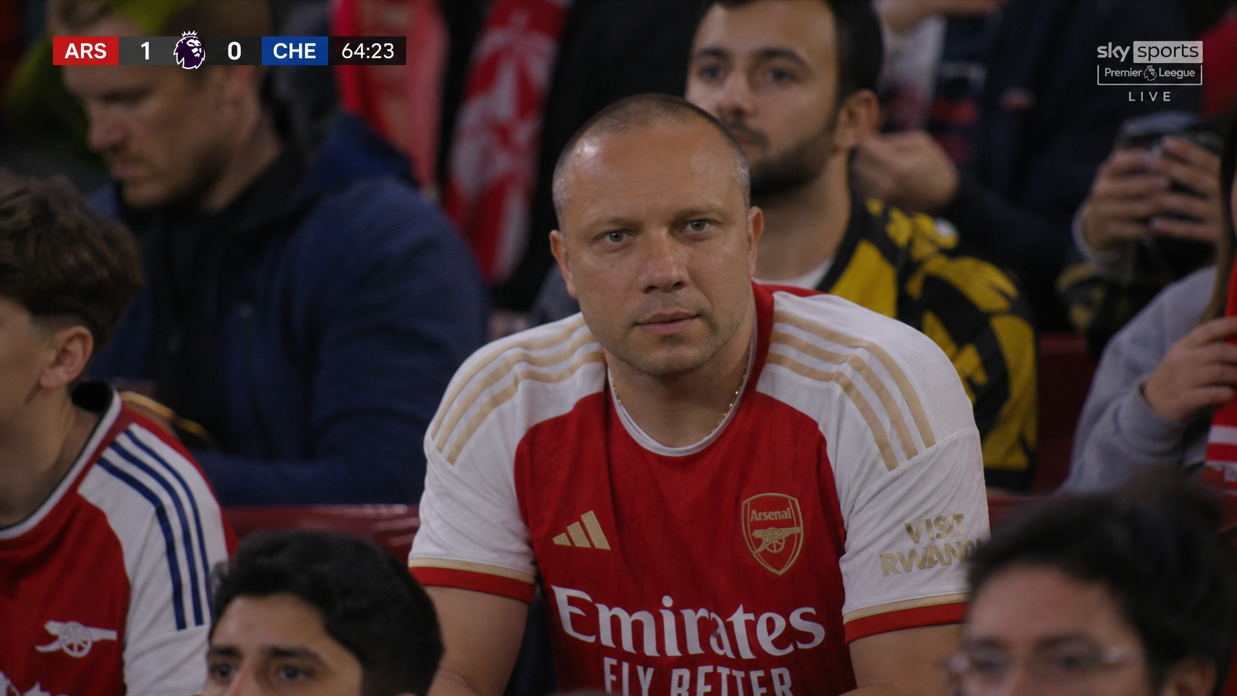 AI English Premier League soccer fan cam image wearing an Arsenal FC jersey with broadcast scoreboard graphics