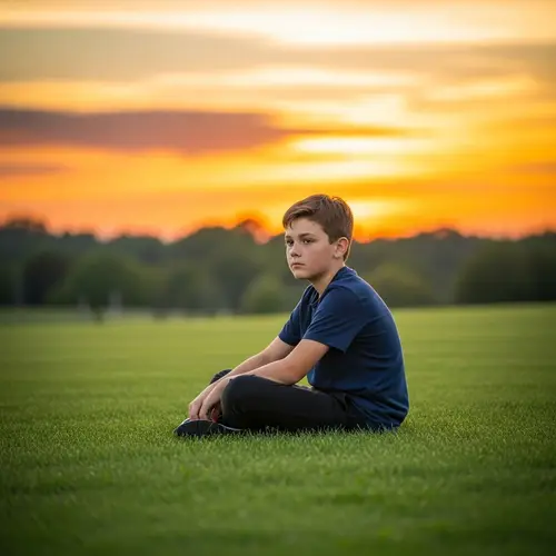 Golden Hour Sunset Portrait: Young Boy On Lush Green Grass