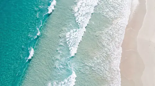 Turquoise Waves and Sandy Shores Aerial Photography