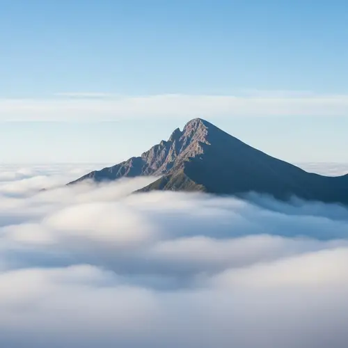 Tranquil Mountain Peak Amidst Gentle White Clouds