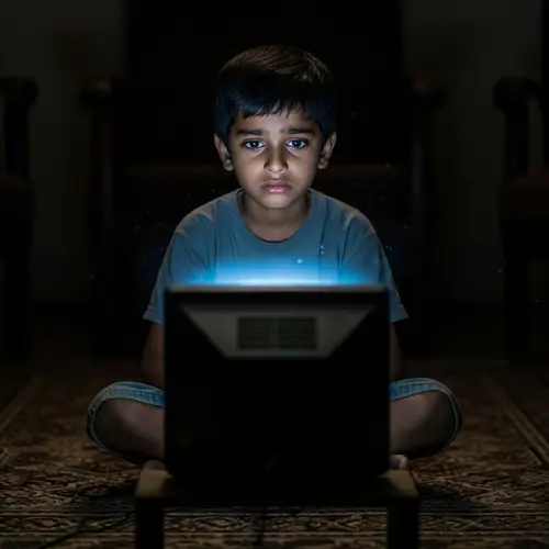 Sad South Asian Boy Alone in Dimly-Lit Room Watching TV