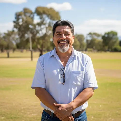 Middle-Aged Hispanic Man Smiling Outdoors in Casual Attire