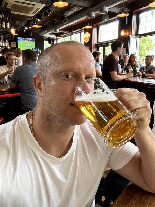 Model Enjoying Beer in a Bustling Bar