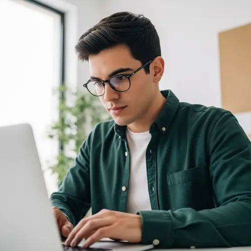 Hispanic Young Man Working on Laptop in Minimalistic Setting