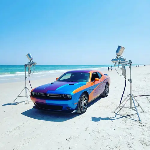 Vibrantly Colored Muscle Car on Beach with Bodyshop Spray Guns