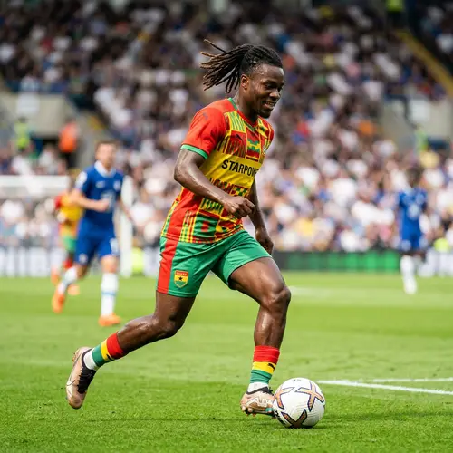Ghanaian Footballer in Traditional Kit: Expertly Navigating the Field