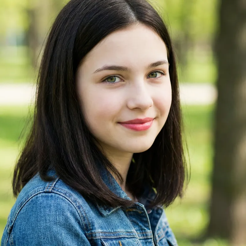 Beautiful 15-Year-Old Girl with Black-Brown Hair, Green Eyes, and Rosy Lips