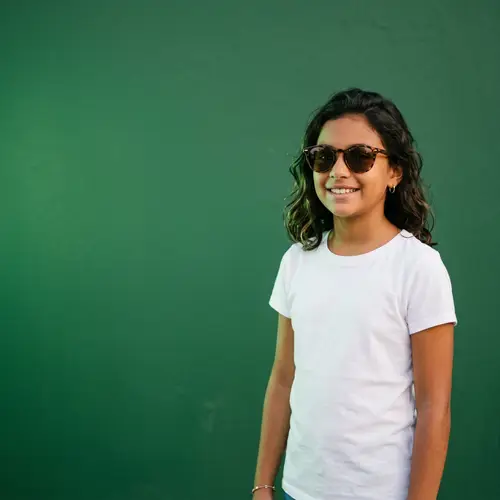 Hispanic Girl in White T-Shirt and Sunglasses | Green Background