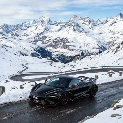 Sleek Black Sports Car against Snowy Mountain Backdrop