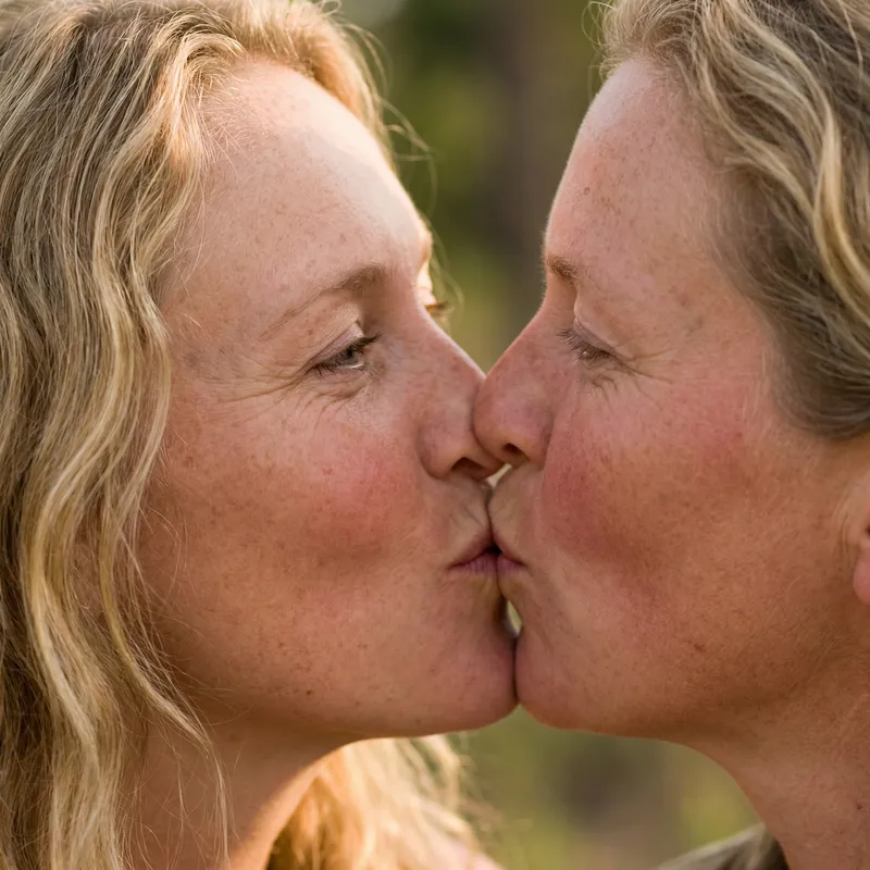 Tender Kiss of a Freckled Couple in Soft Light