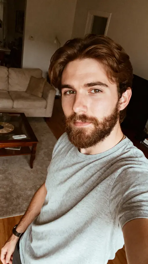 29-Year-Old Man with Brown Hair in His Living Room Selfie