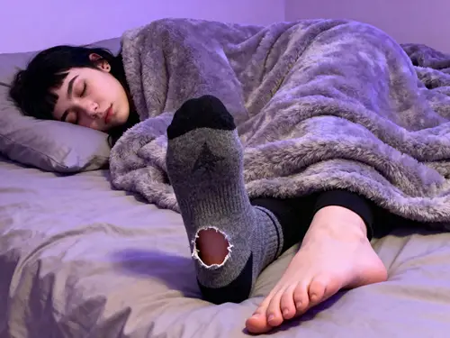 Goth Girl's Cozy Sleep Scene with Whimsical Sock