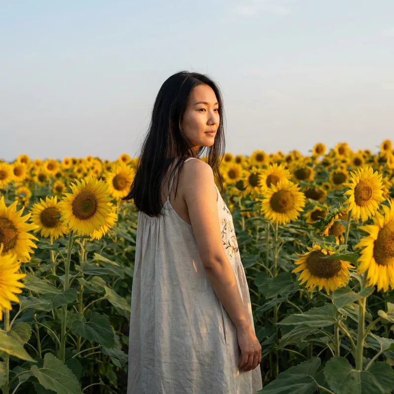 Asian Woman in Flowy White Dress Amidst Sunflower Field