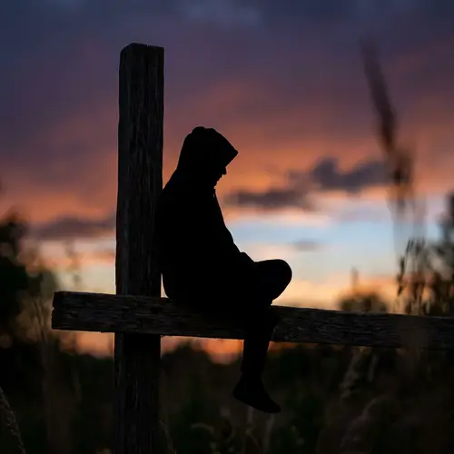 Contemplative Silhouette Miniature Figure in Hood at Twilight