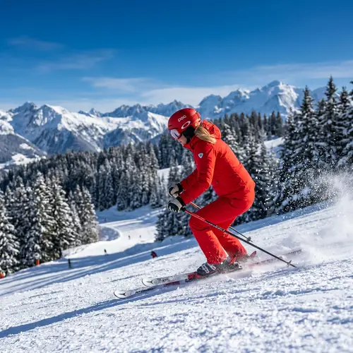 Athletic Woman Downhill Skiing in Red Snowsuit