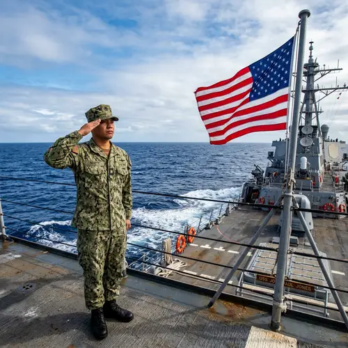 Filipino US Navy Sailor Saluting American Flag at Sea