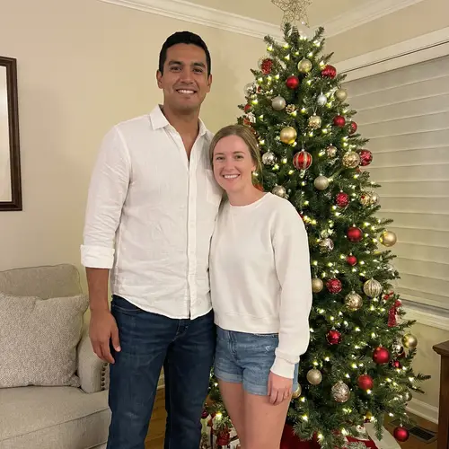 Festive Christmas Tree Decor: Tall Hispanic Male and Short Caucasian Female