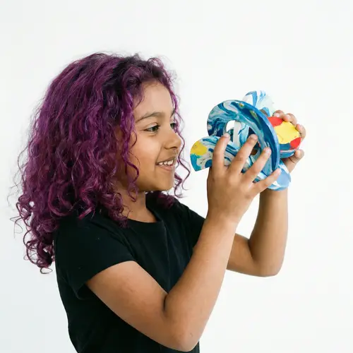 Vibrant South Asian Girl Playing with Blue and White Toy
