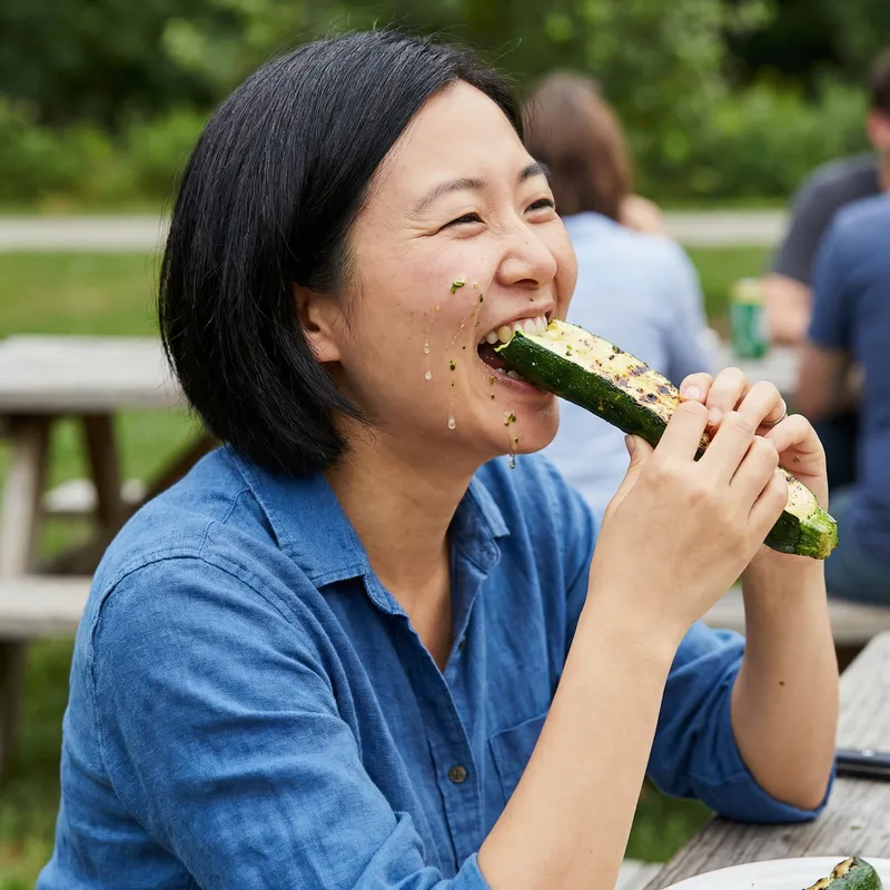 Realistic Photo of Asian Woman Eating Juicy Courgette Realistic Photo of Asian Woman Eating Juicy Courgette