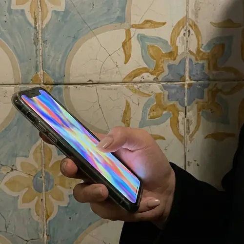 East Asian Hand Holding Smartphone: Modern Tech in Vintage Setting