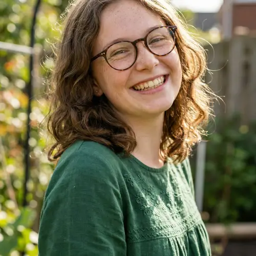 Smiling Caucasian Girl with Glasses in Modest Green Top