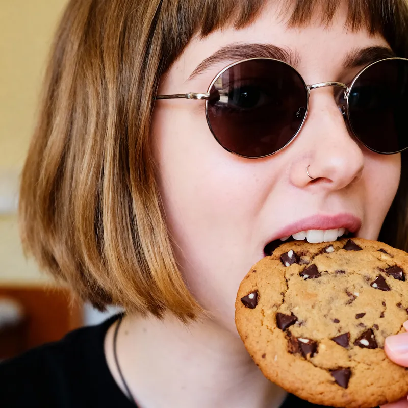Girl with Sunglasses Enjoying a Chocolate Cookie