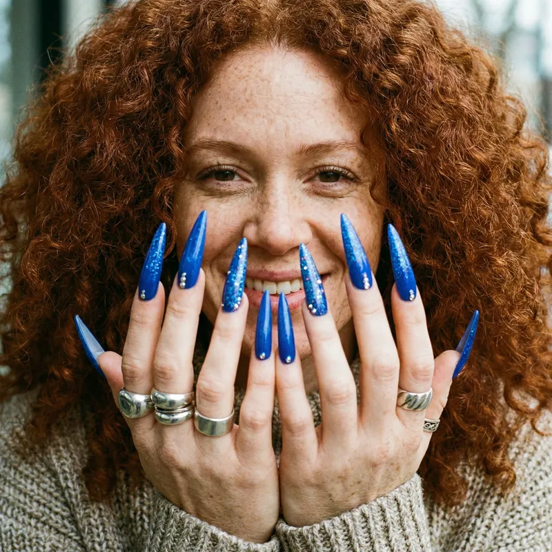 Curly Redhead Woman Showing 5-Inch Blue Nails in Close-Up View