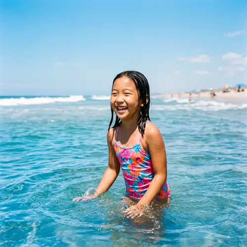 Euphoric Asian Girl Enjoying in Sparkling Ocean Water