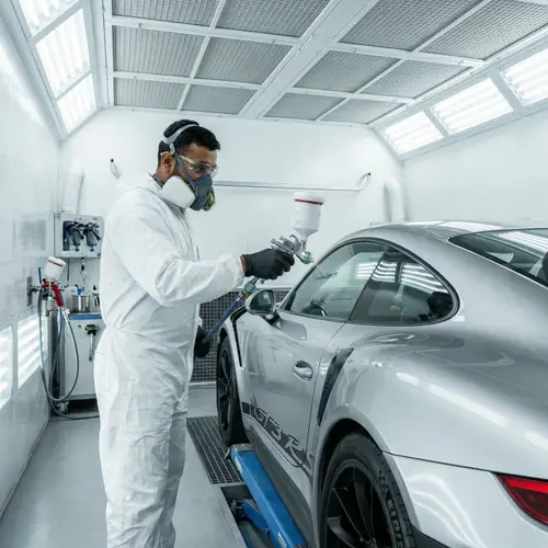Professional South Asian Mechanic Painting High-End Car