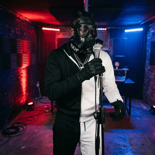 Masked UK Drill Rapper with TKH⁸ Gas Mask in Mysterious Room