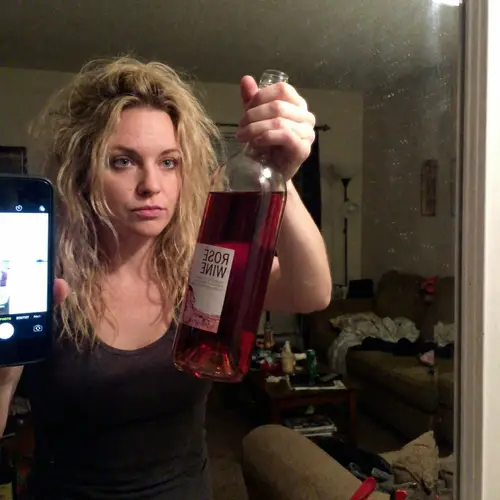 Caucasian Woman with Blue Eyes and Blonde Hair Holding Rose Wine