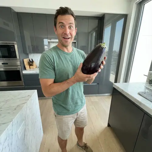 Asian Man Marvels at Large Eggplant in Modern Kitchen